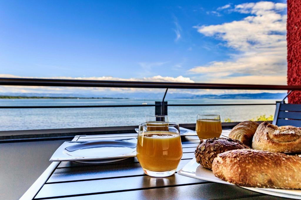 uma mesa com uma bandeja de pão e dois copos de cerveja em Auszeit Apartment LAKESIDE direkt am Bodensee mit Privatstrand und atemberaubendem See- und Alpenpanorama, Sonnenbalkon, schnelles WLAN, kostenloser Tiefgaragenstellplatz, direkt am Bodenseeradweg, für bis zu 2 Personen em Friedrichshafen