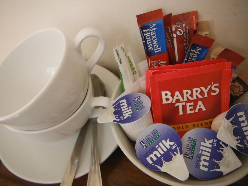 a plate with cups and toothbrushes and a cup and books at Inspiration Lodge in Anascaul