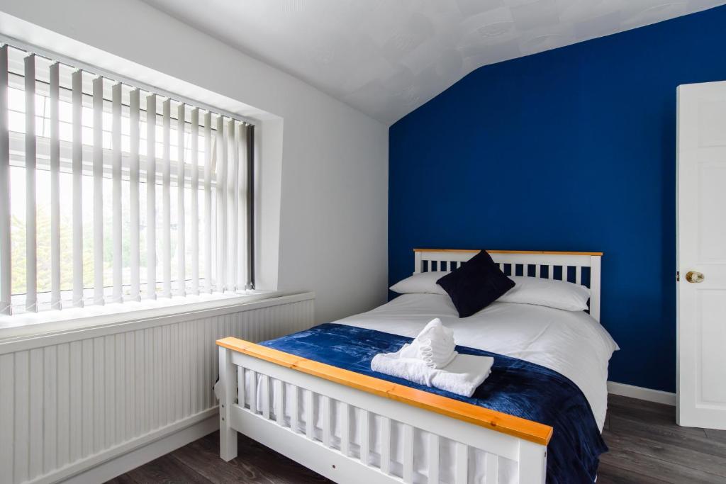 a bedroom with a blue wall and a bed at Clarence Heights in Newport