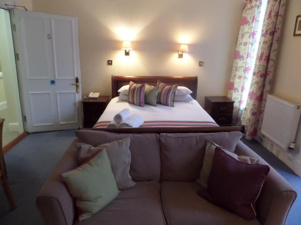 a bedroom with a couch in front of a bed at Harry's Hotel & Restaurant in Aberystwyth