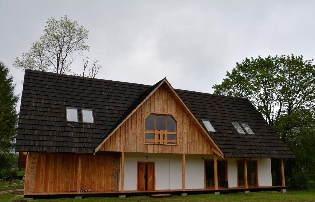 una casa de madera con techo de gambrel en Michniowiec 6, en Czarna