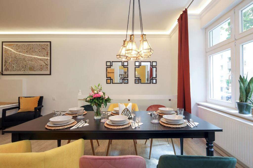 uma sala de jantar com uma mesa preta e cadeiras em 5 Personen Altbau nahe Kurfürstendamm - Shakespeare em Berlim