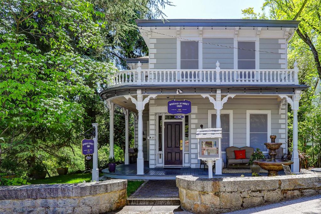 a small white house with a porch and a balcony at Broad Street Inn in Nevada City