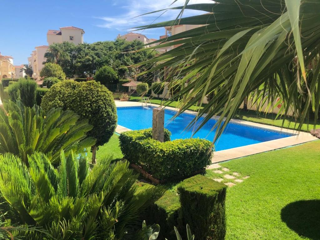 uma piscina num quintal com árvores e arbustos em Bonita y moderna habitación a 300m de la playa em Benalmádena