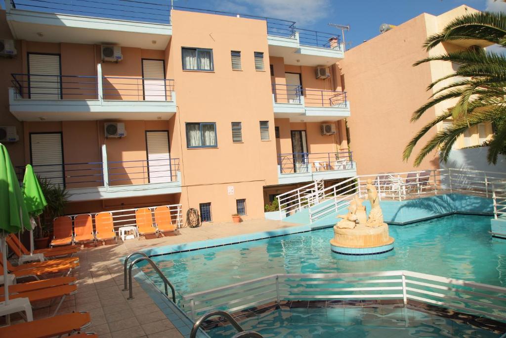 a swimming pool in front of a building at Emilia Hotel Apartments in Rethymno