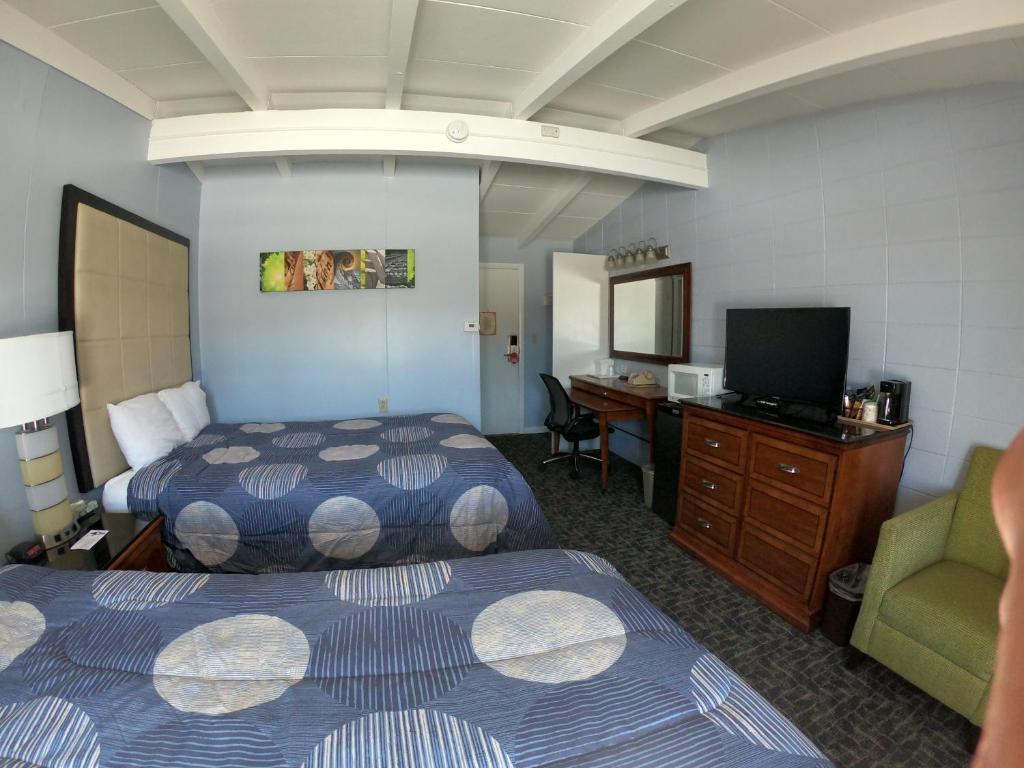 a hotel room with two beds and a desk at Copper Lantern Motor Lodge in West Brookfield