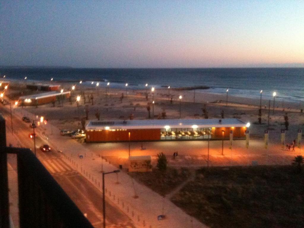 a view of a beach at night with lights at Sunset Beach in Costa da Caparica