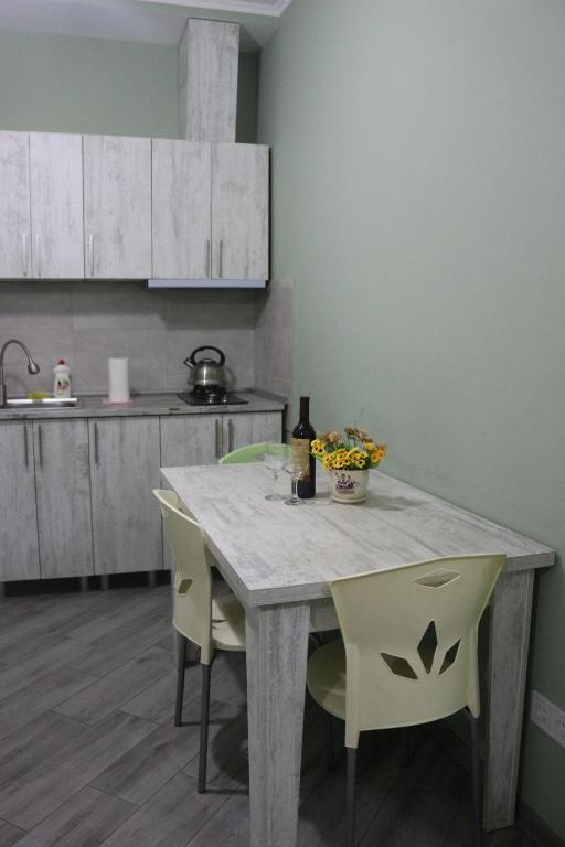 uma cozinha com uma mesa com cadeiras e uma garrafa de vinho em Batumi Loves you Apartment em Batumi