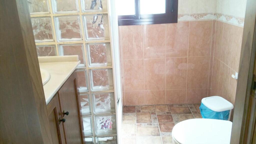 a small bathroom with a toilet and a sink at TRUJILLO HOLIDAY HOME con PISCINA in Conil de la Frontera