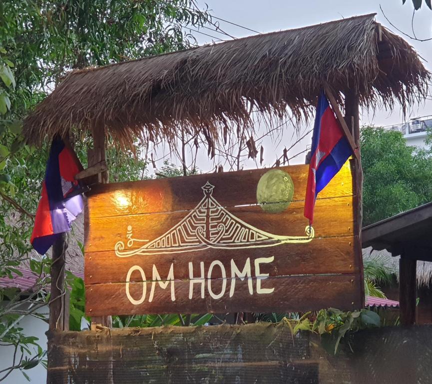 una señal que dice en casa con dos banderas en Om Home, en Sihanoukville