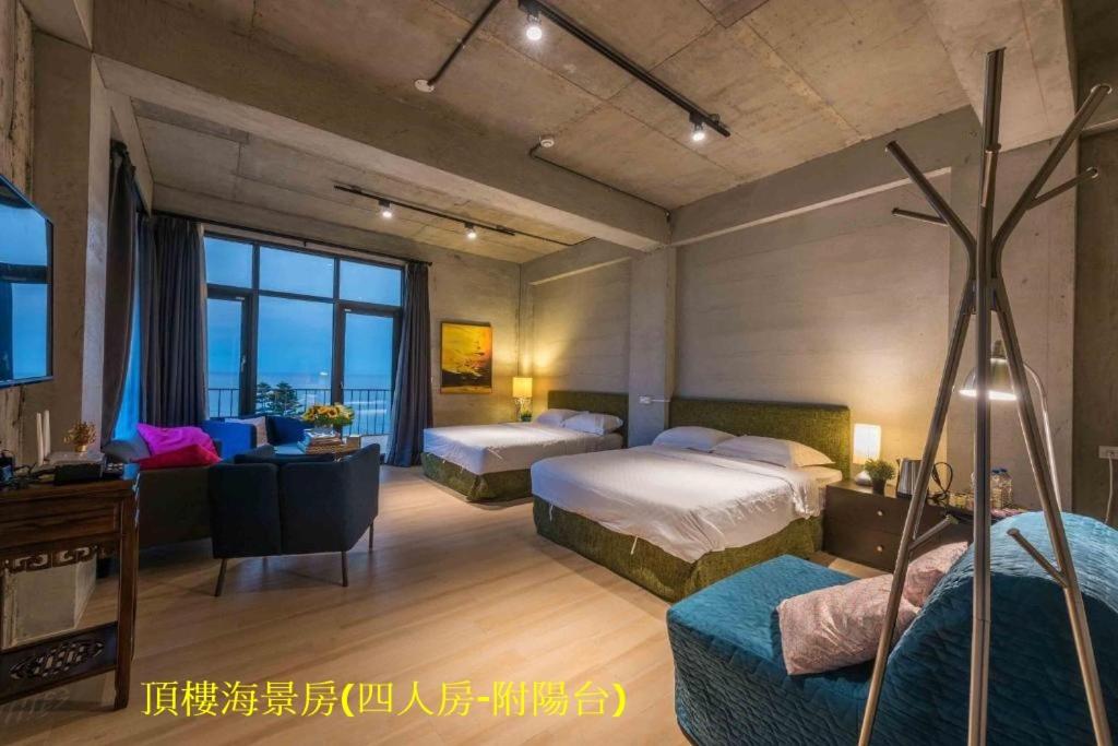 Habitación de hotel con 2 camas y sofá en Sea Forest Homestay, en Suao