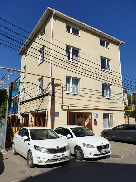 two white cars parked in front of a building at Мини-гостиница У МОРЯ Джемете in Anapa