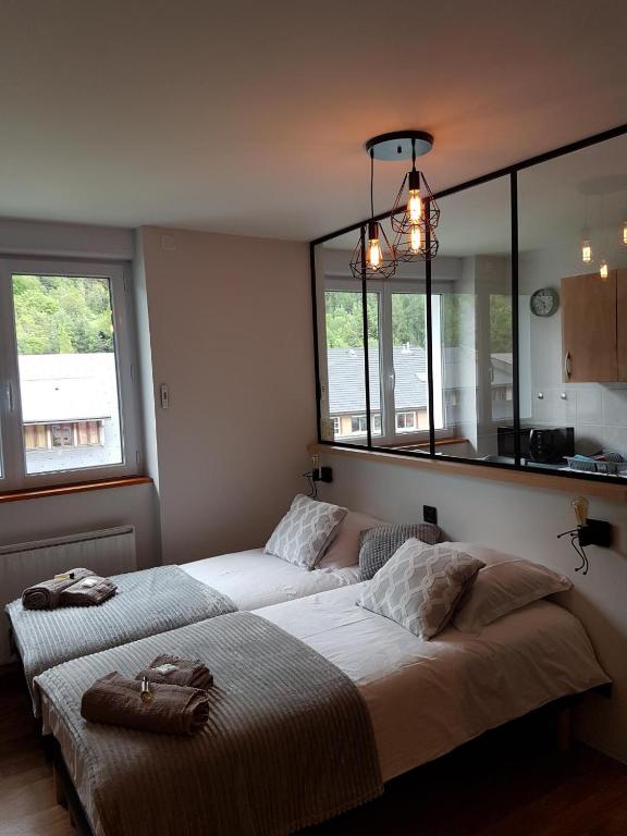 a bedroom with two beds and a large window at STUDIO 21 M2 TOUT EQUIPE in Modane