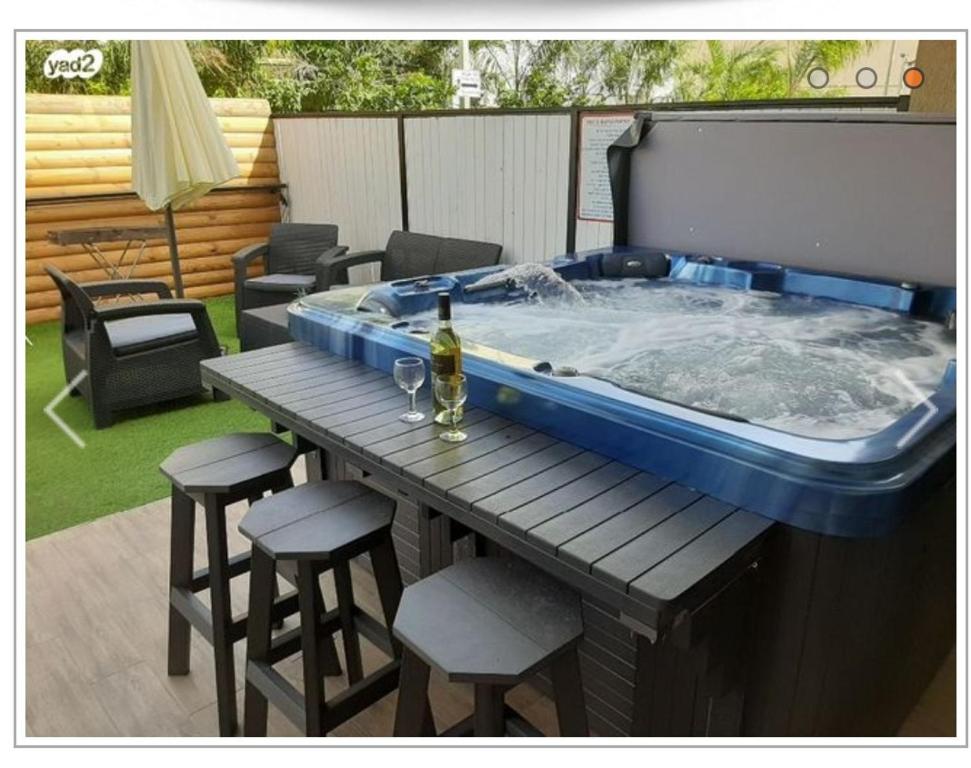 a large hot tub sitting on a table with stools at דירות נופש וג'קוזי באילת - אילן vip in Eilat