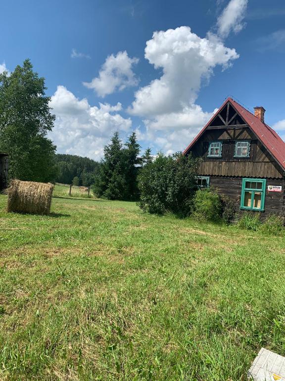a house in a field with a haystack at DOMY na GÓRCE in Narty