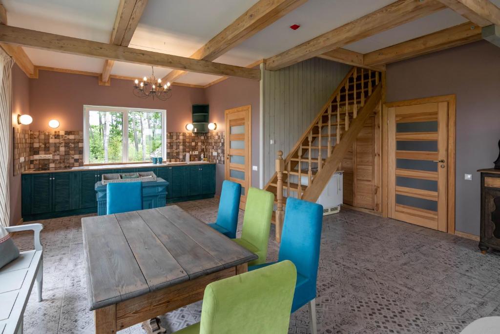 ein Esszimmer mit einem Holztisch und Stühlen in der Unterkunft Pagojaus Apartamentai in Karališkiai