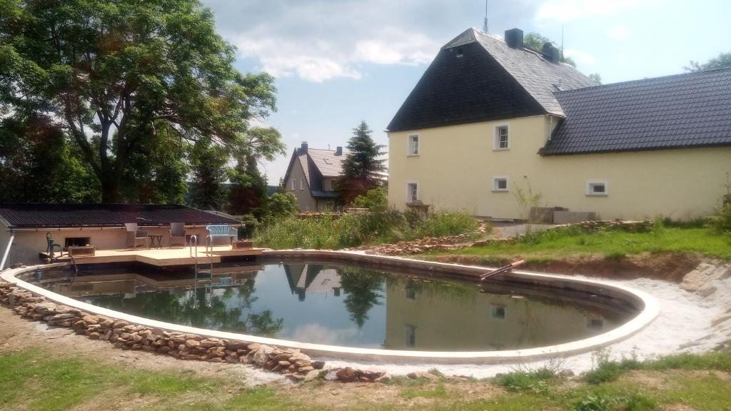 a pool in a yard next to a house at Gasthaus Ruebenau in Rübenau