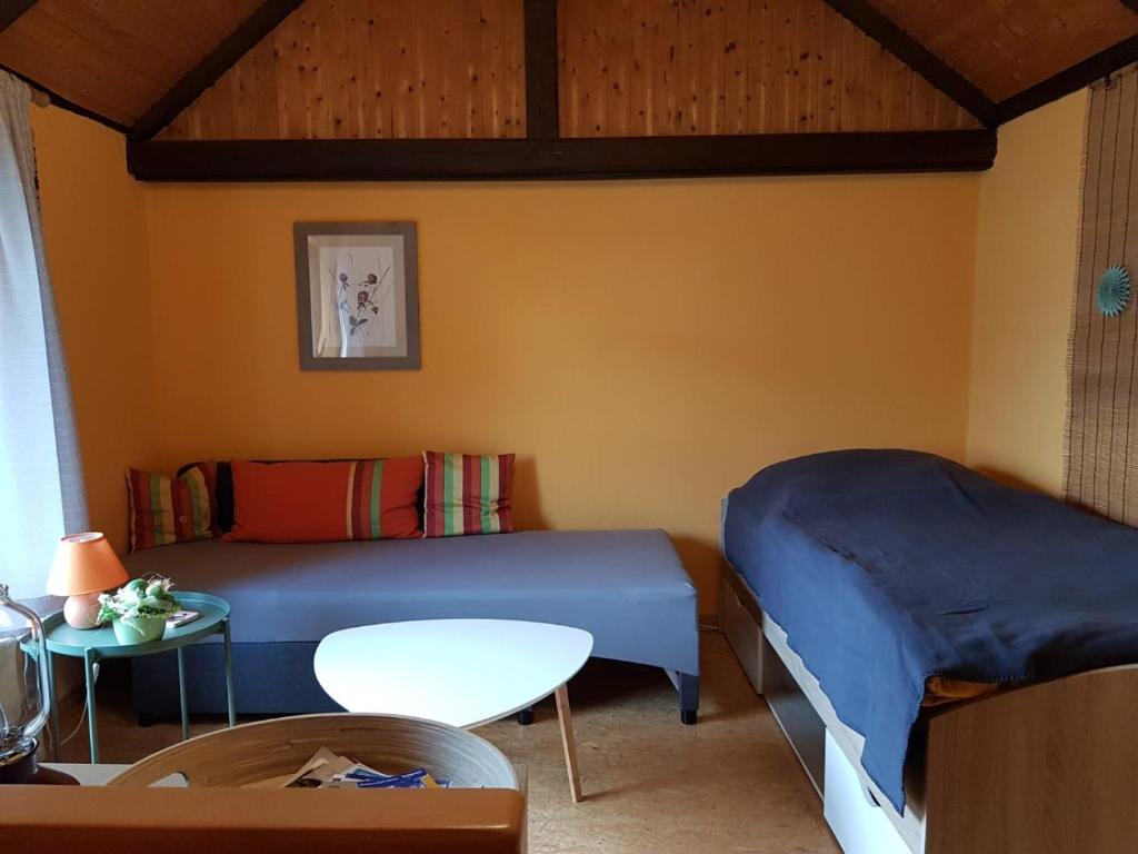 a room with a bed and a table and a bed and a couch at Ferienwohnung Zum-alten-Kirschbaum in Limburg an der Lahn