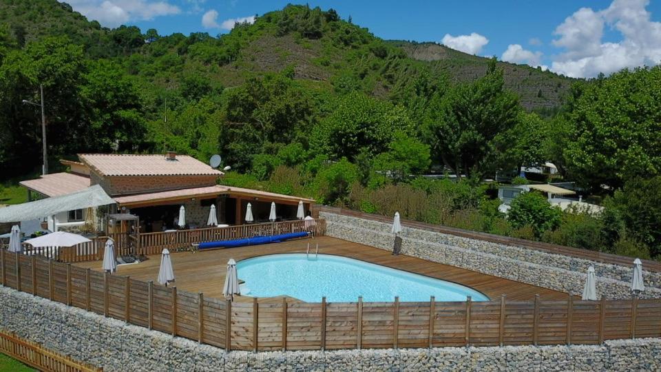 une piscine entourée d&#39;une clôture en bois. dans l&#39;établissement Camping du Bourg, à Digne-Les-Bains