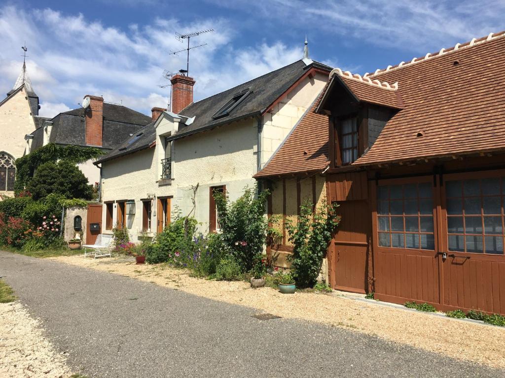 une grande maison blanche avec un toit marron dans l'établissement LA MAISON DE LUCIE, à Veuil