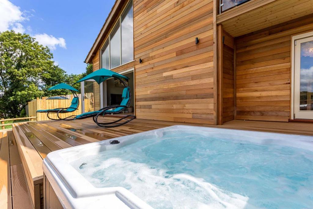 een hot tub op het terras van een huis bij Blackdown Views - New 6 Bedroom Eco House in Dunkeswell
