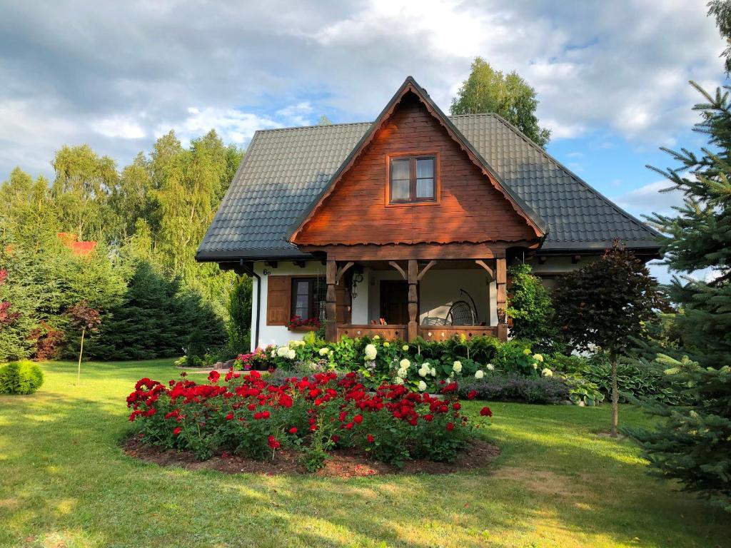 a house with a garden with red and white flowers at Dom w Gruszkach - Puszcza Białowieska in Narewka