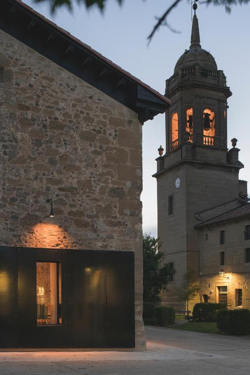a building with a clock tower in front of a building at Casa Grande Hotel in Grañón