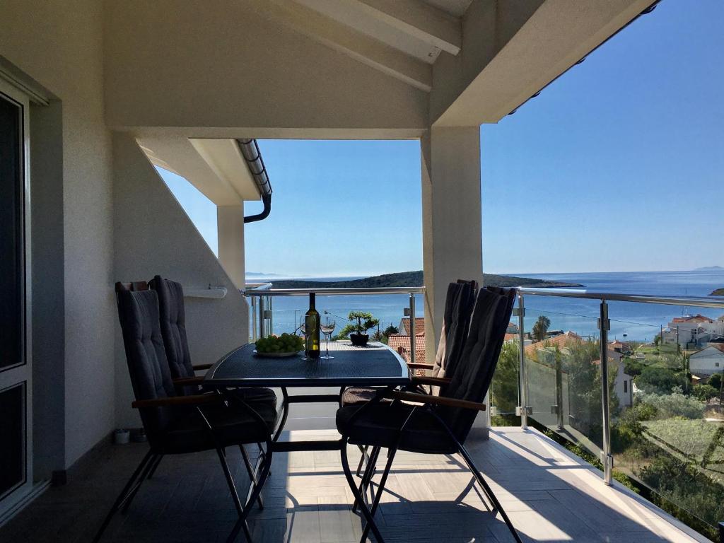 a table on a balcony with a view of the ocean at Ada Vis Apartments in Vis