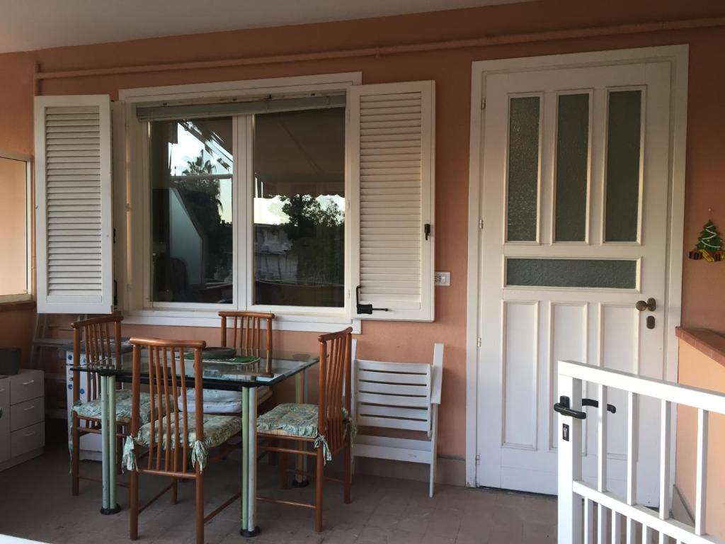 a table and chairs on the porch of a house at La Perla di Ponente in Ospedaletti