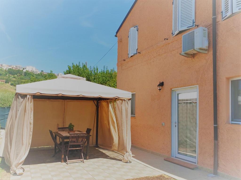 a table and chairs under a tent next to a building at A casa de Fiore in Montegranaro