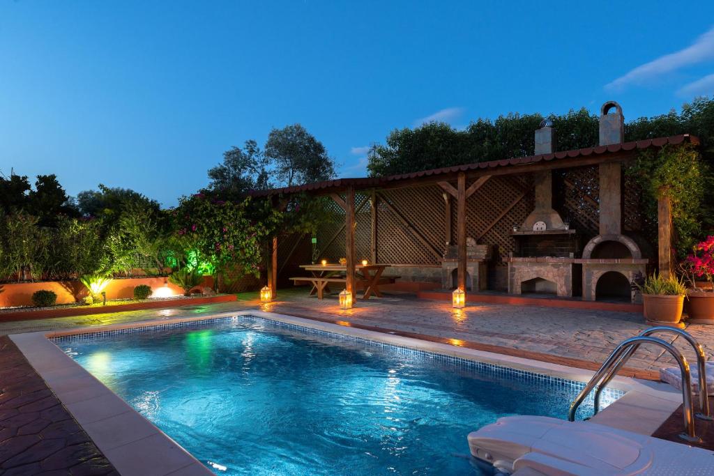 a swimming pool in a backyard with a gazebo at Antico Rosso Villa in Ialysos