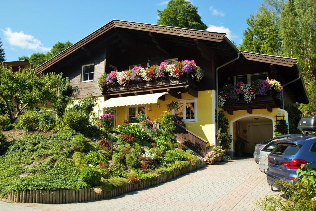 uma casa amarela com caixas de flores em Appartement Ripper em Saalbach-Hinterglemm