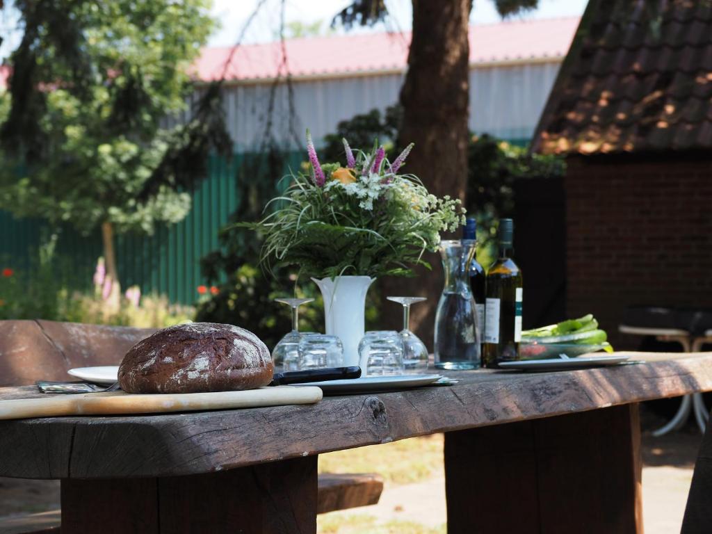 una mesa con una barra de pan y un jarrón de flores en Ferienhof Meyer, en Nahrendorf