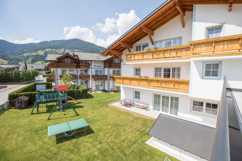a large yard with a playground in front of a building at Aparthotel Pichler in Flachau