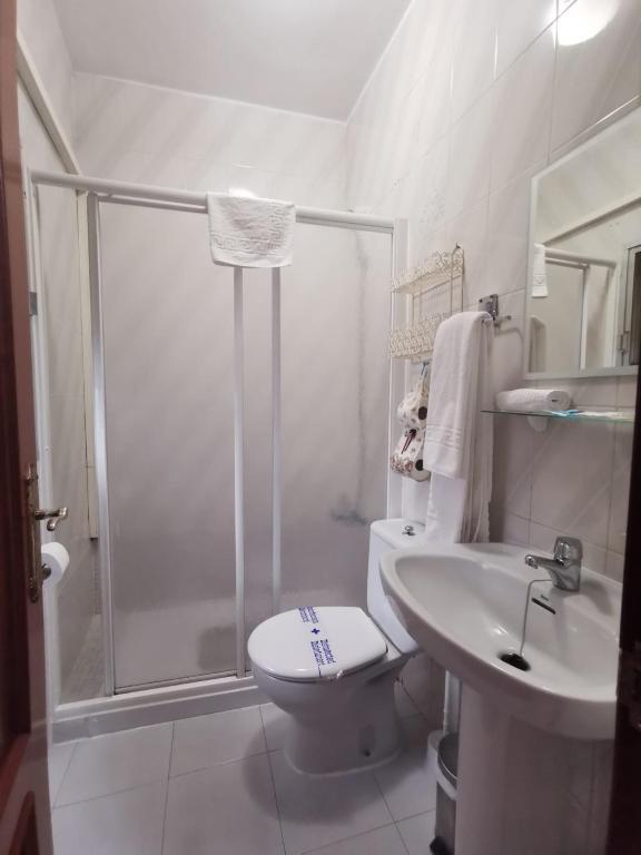 Un baño con ducha, inodoro y lavabo. en Hostal Senero, en Mérida