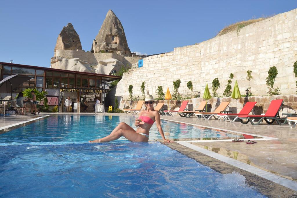 a woman in a bikini sitting in a swimming pool at Grand Elite Cave Suites in Goreme