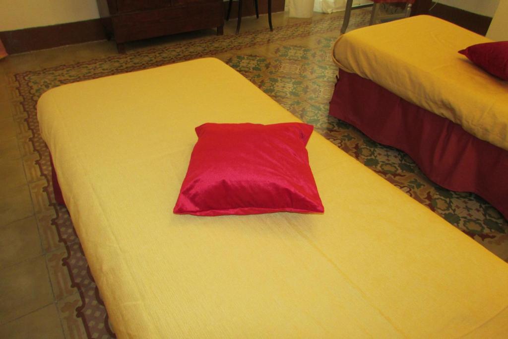 a red pillow sitting on top of a bed at Guesthouse City Center in Bari
