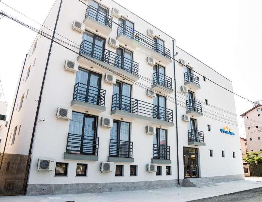 ein weißes Gebäude mit schwarzen Fenstern und Balkonen in der Unterkunft Hotel Premium in Eforie Nord