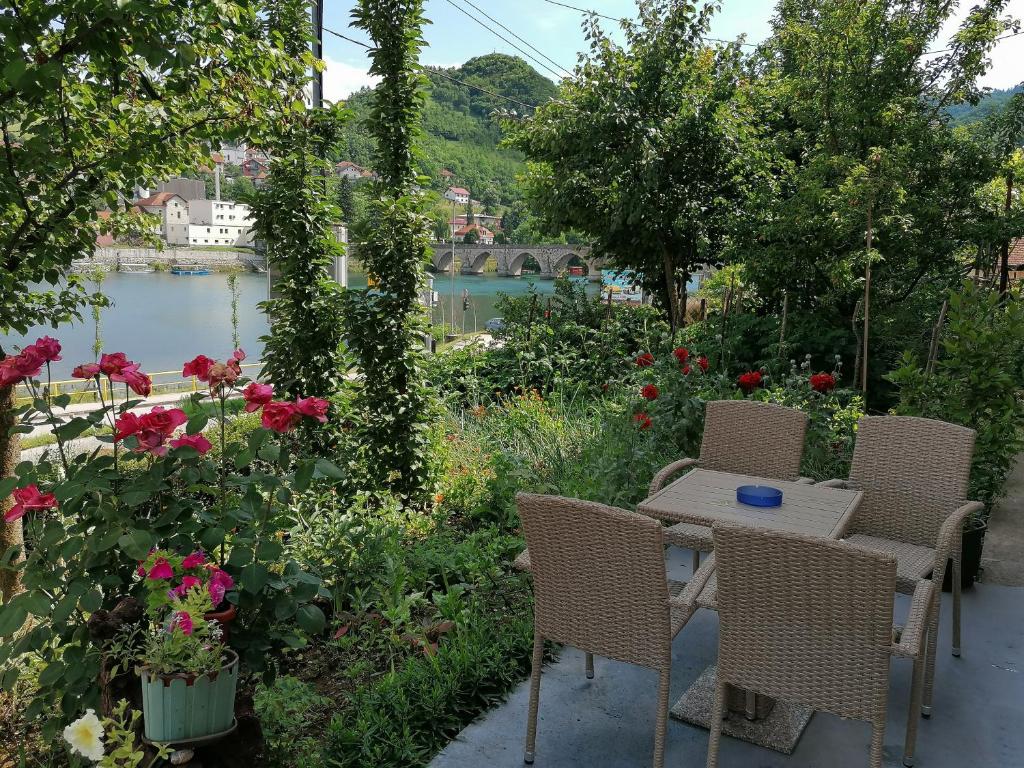 een tafel en stoelen in een tuin met bloemen bij Apartment Danijel in Višegrad