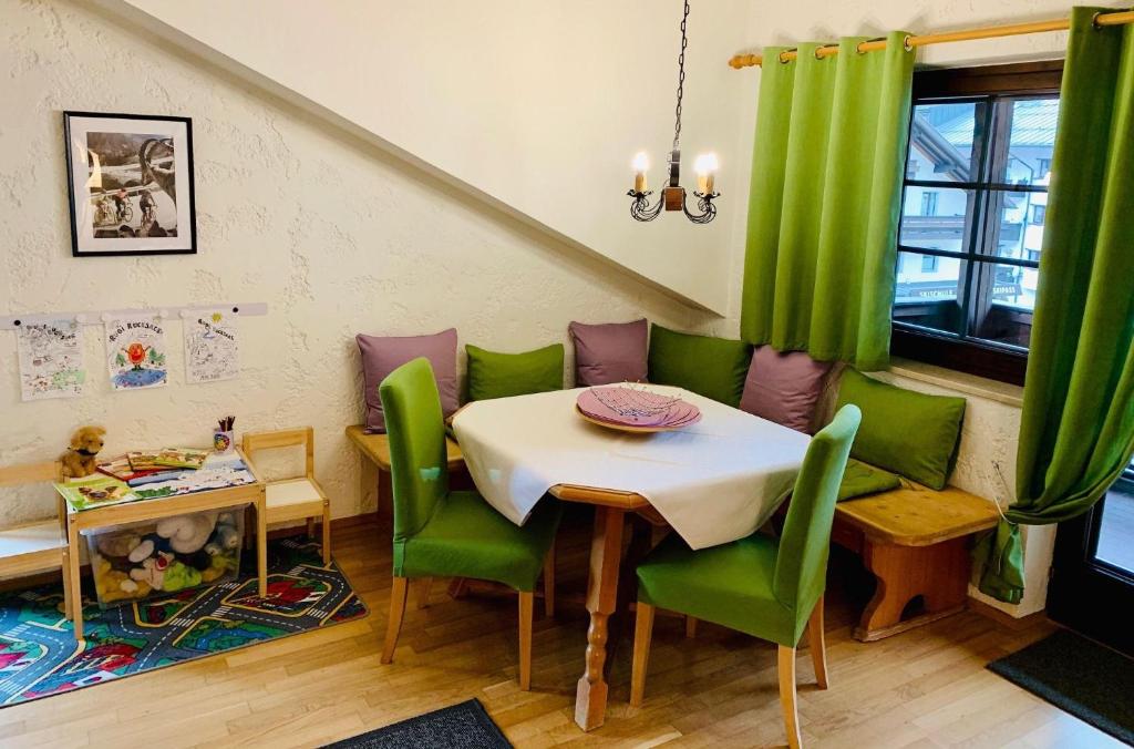 a dining room with a table and green chairs at Appartement-Azalea in Oetz