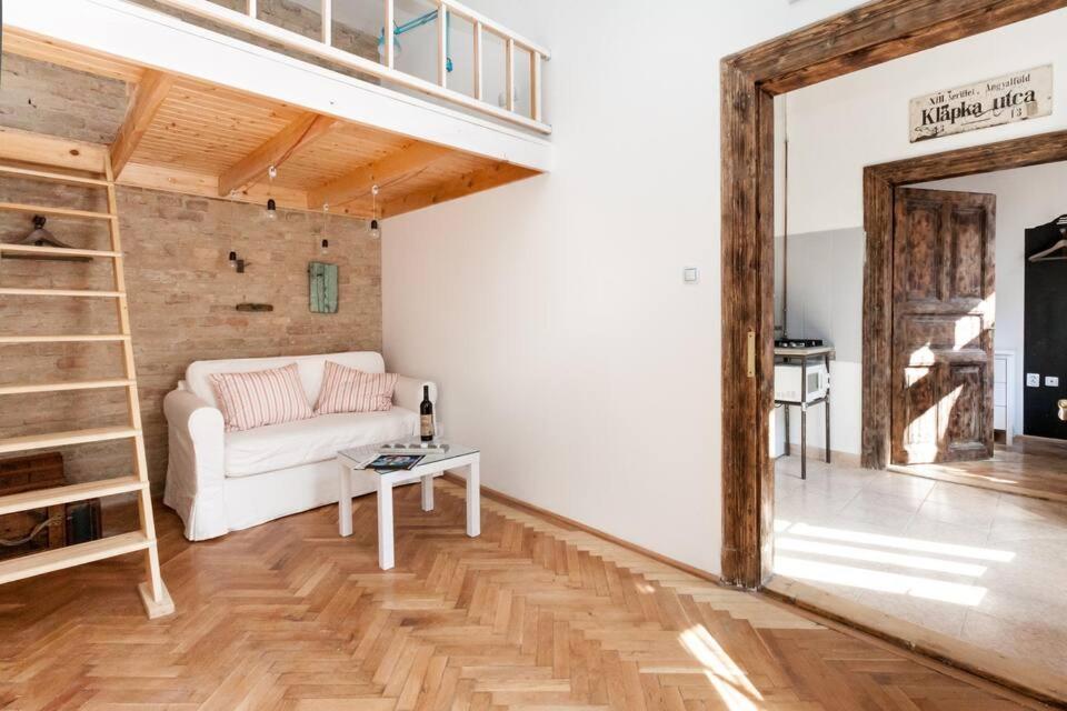 a living room with a white couch and a loft at Little Whistle in the heart of Jewish district with AC in Budapest