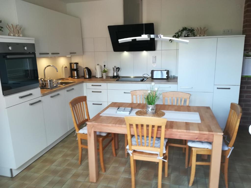 a kitchen with a wooden dining table and chairs at Ferienwohnung Meyer in Bleckede
