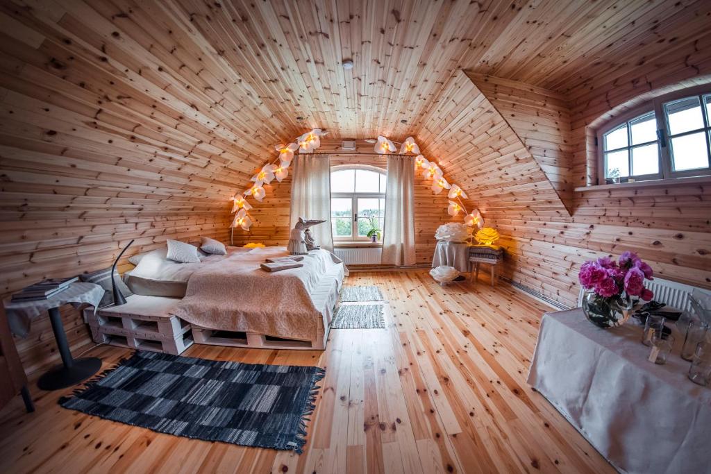 ein Schlafzimmer mit einem Bett in einem Holzzimmer in der Unterkunft HANDMADE LATGOLA - vairāk kā vienkārši "naktsmītne" in Līvāni