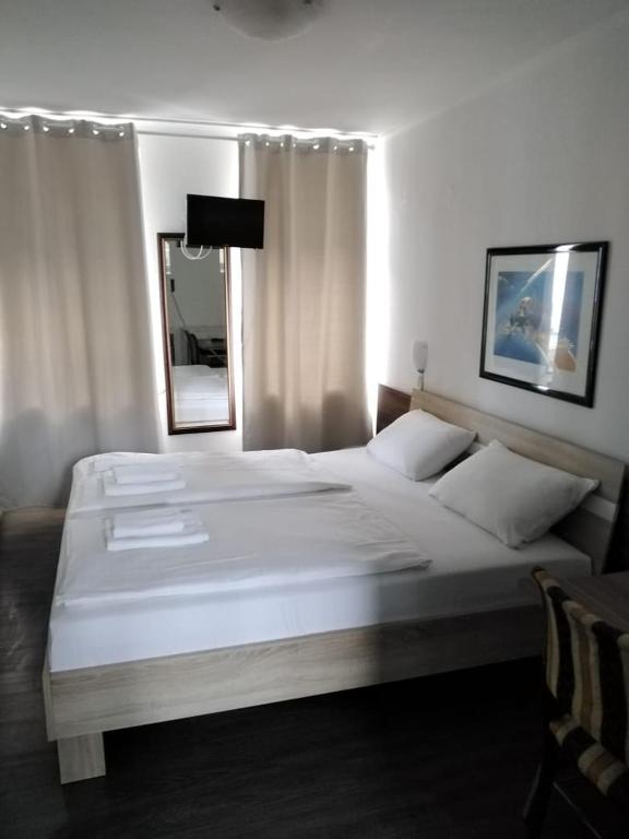 a bedroom with a large white bed and a mirror at Hotel Berliner Hof in Düsseldorf