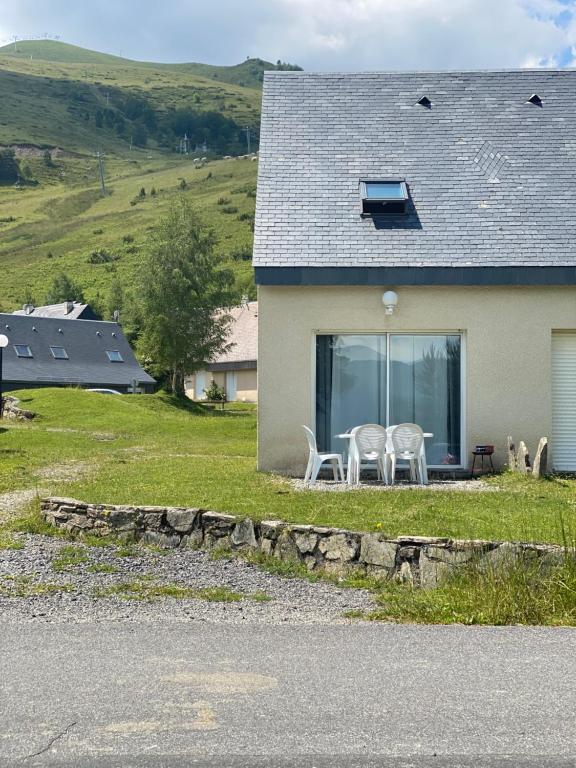 維陸洪的住宿－Chalet de montagne au pied des pistes station Val Louron，房屋设有两把白色椅子和窗户