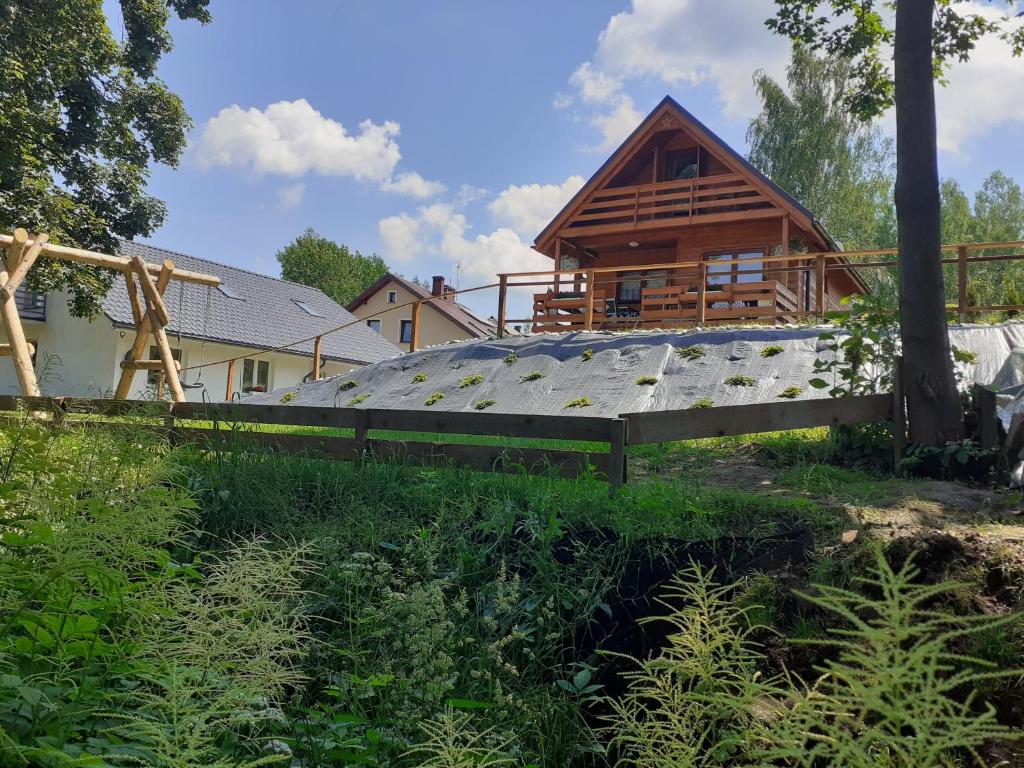 una casa con techo de madera y un edificio en Domek na górce, en Duszniki-Zdrój