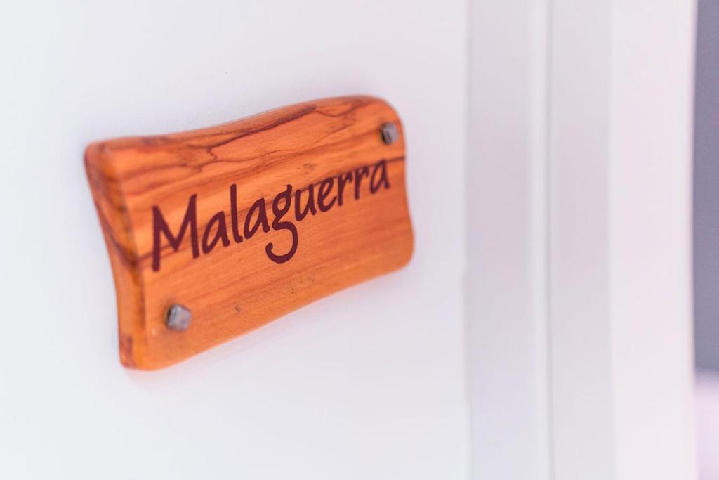 a wooden sign that reads malagiographical on a wall at B&B L'Orlando Furioso in Palermo