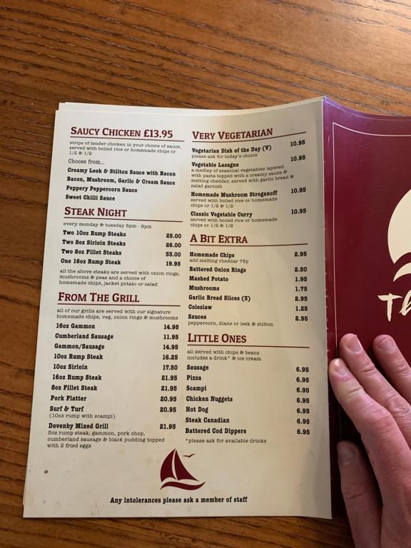 a person holding a menu for a restaurant at DOVENBY SHIP in Tallentire