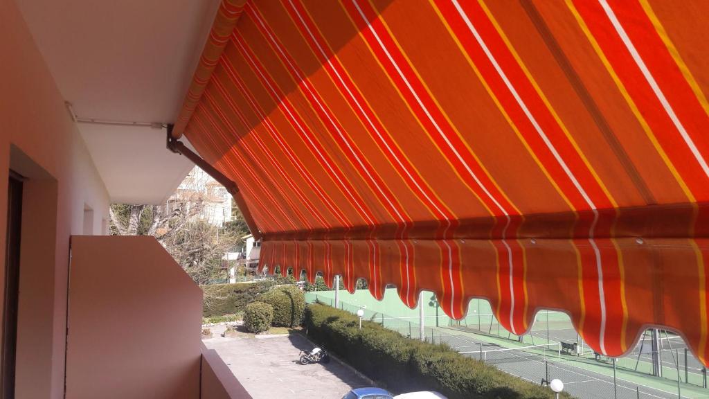 een oranje en rode paraplu op een balkon bij Studio 300m plage in Saint-Laurent-du-Var