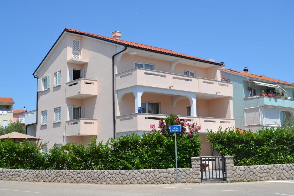 a large white building with a blue sign in front of it at Apartment Stella di Mare in Krk
